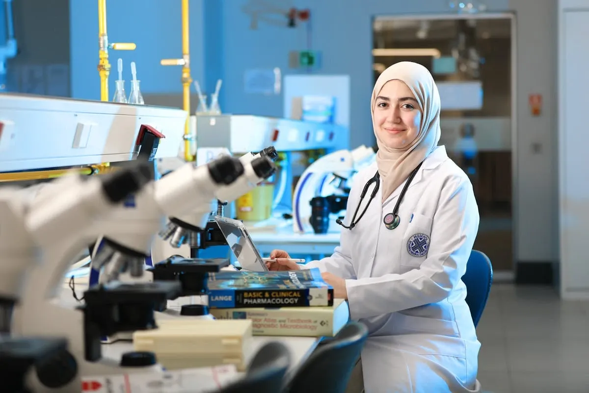 A female medical student in hijab and apron working in the hospital lab