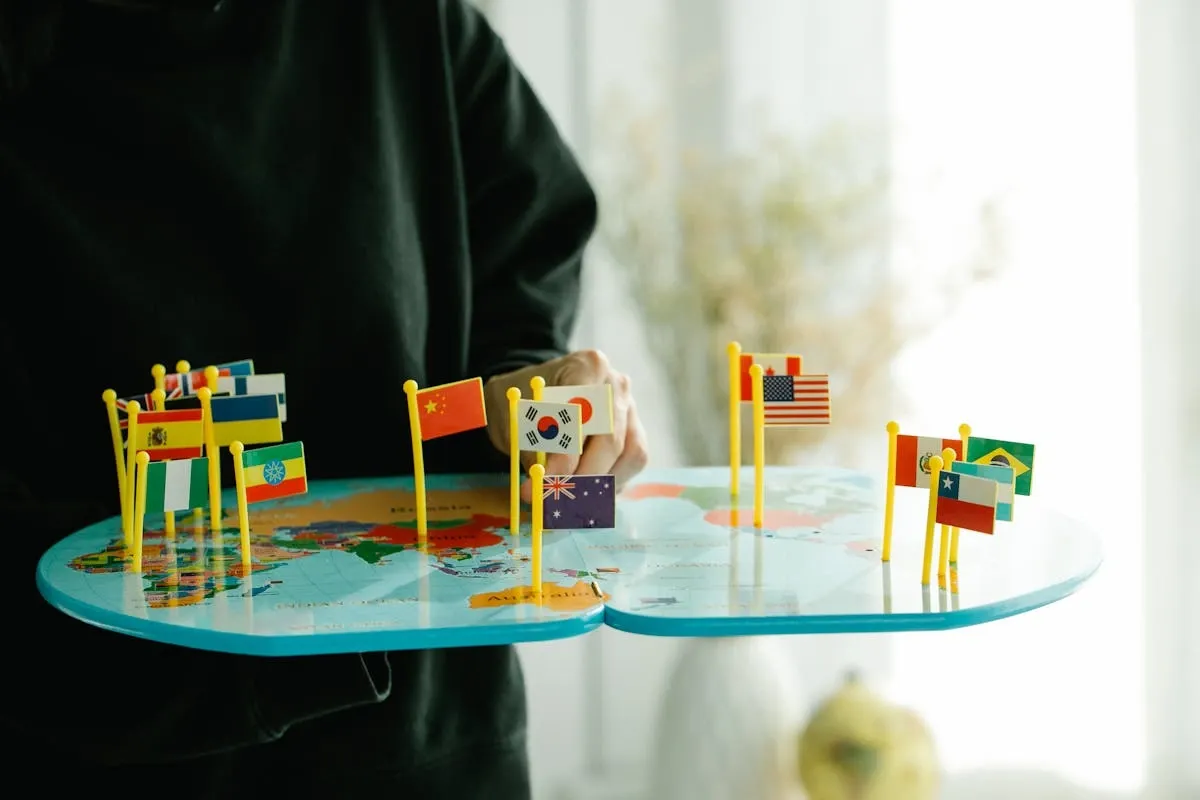 "Person holding world map with international country flags representing global language learning and cultural diversity"