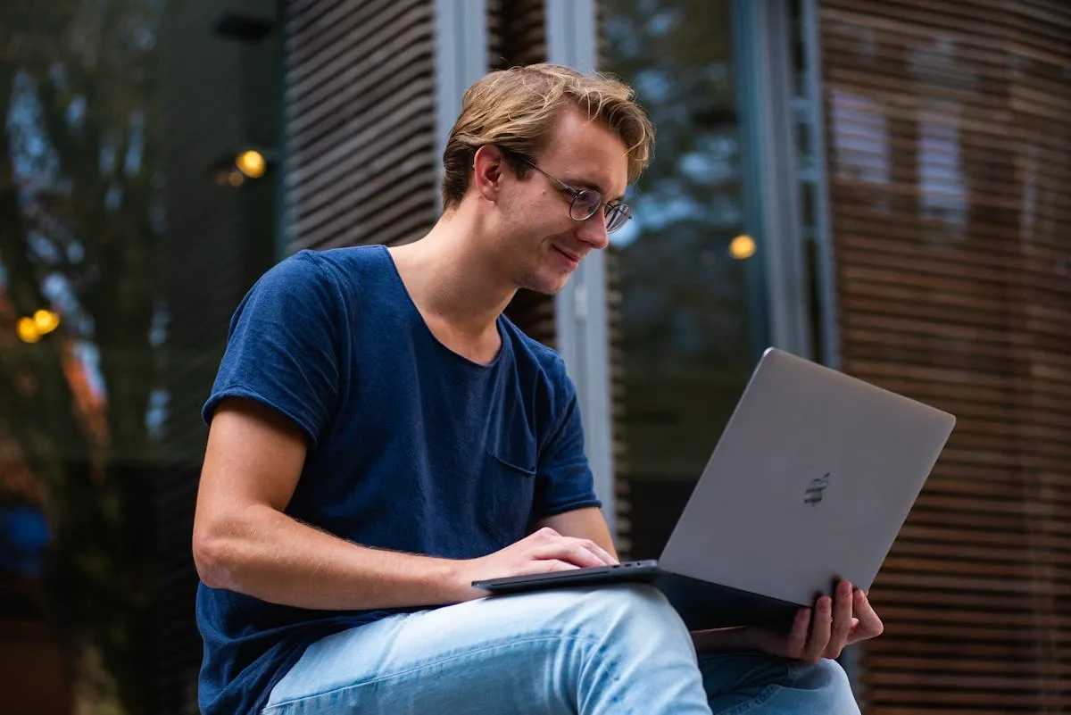 a man sitting with his laptop